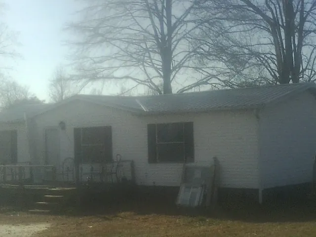 New metal roof on a white painted brick home on a foggy morning in Pine Meadow