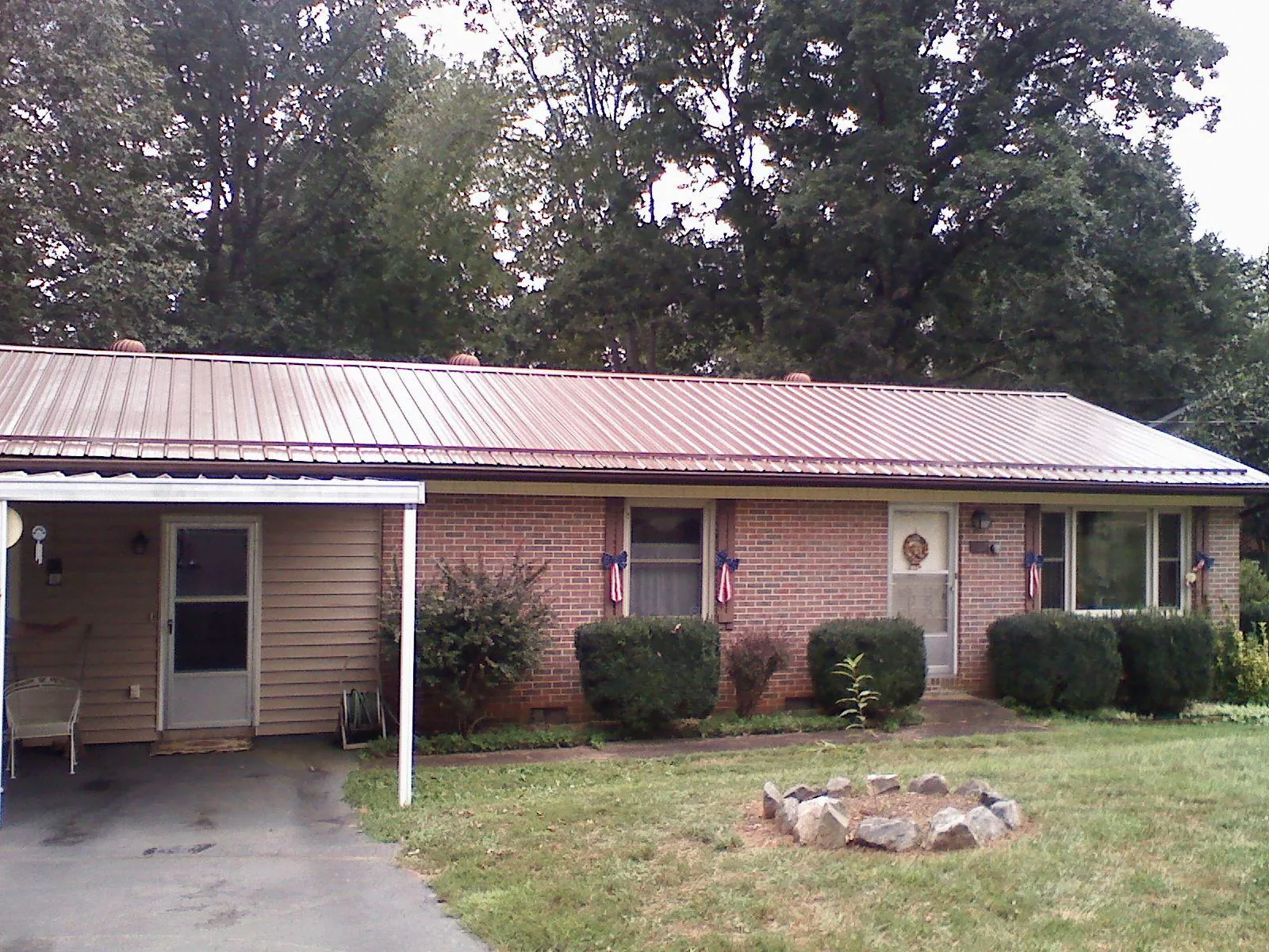 Bronze metal roof and carport on a brick ranch home — Roof Repair work by our crew in Pine Meadow